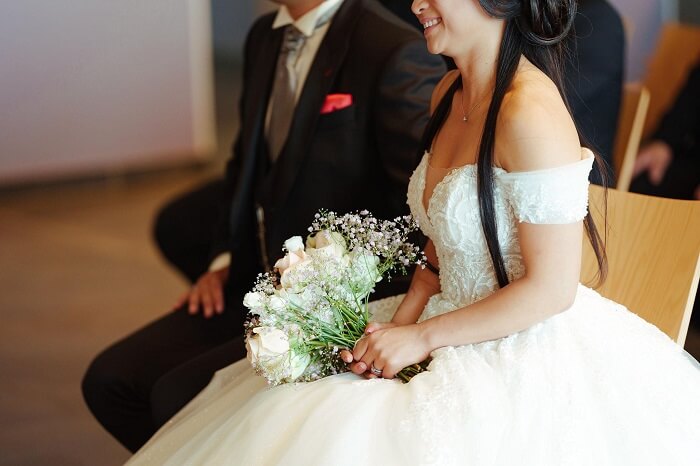 The wedding dress adds a touch of elegance and gentleness to the bride.
