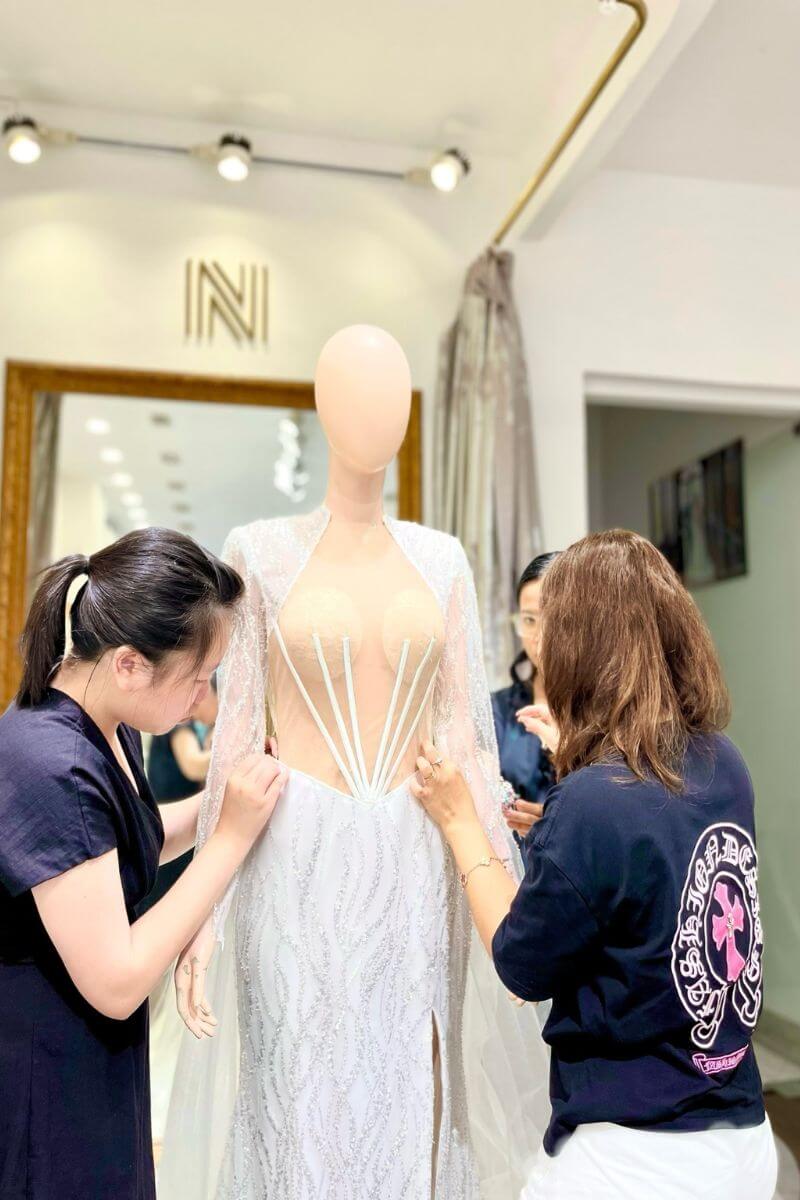 Nicole Bridal tailor is attaching accessories to the wedding dress
