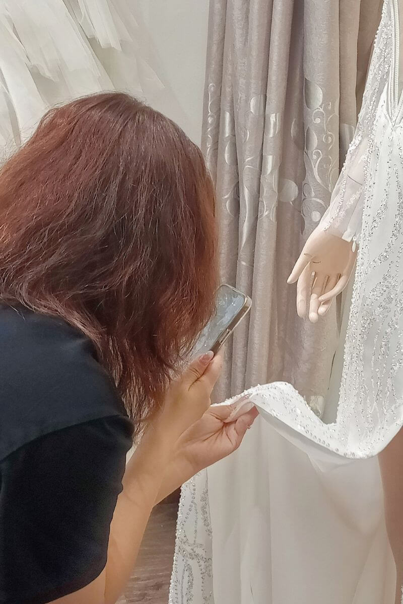 Our tailor is taking photos with wedding dresses to send to customers