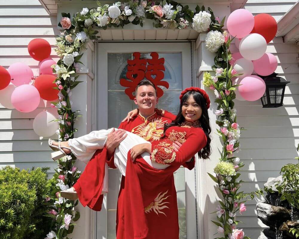The bride and groom wear traditional red ao dai
